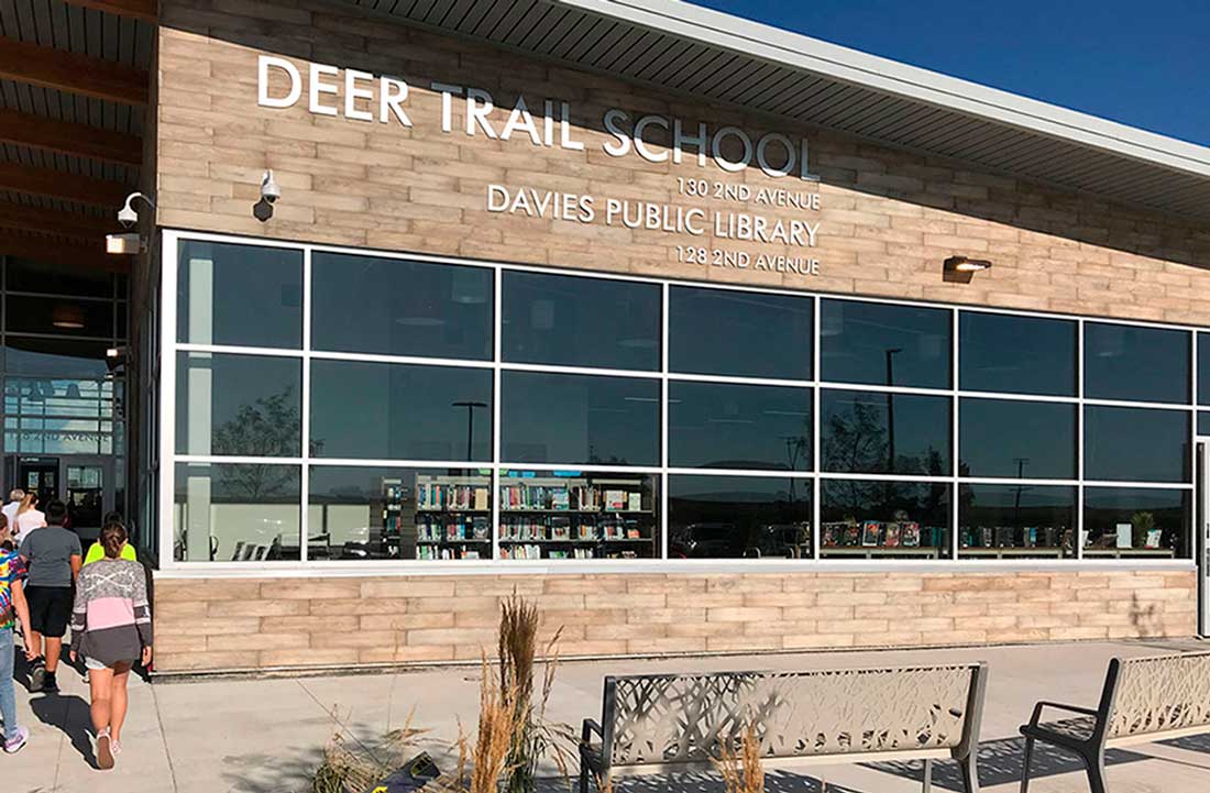 Group of students walking into the entrance of the Deer Trail School Library