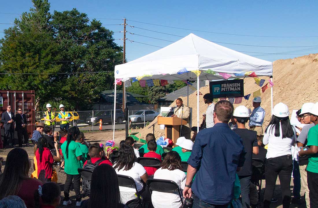 Mayor Hancock speaking from a podium to announce the groundbreaking to a group of students and faculty.